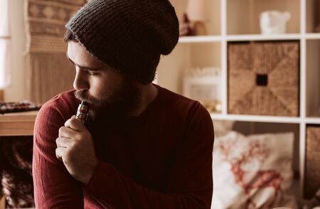Trendy man using a vaper - Christmas and Winter Seasonの写真素材