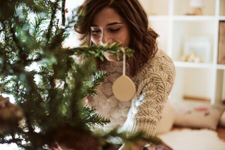 Woman decorating Christmas Tree at home - Winter Seasonの写真素材