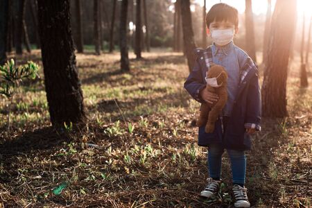 Portrait of a little kid and teddy bear using air masksの写真素材
