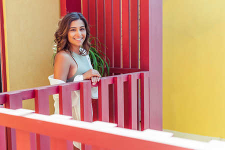 Latin young woman enjoying the sun on the balconyの写真素材