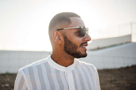 Portrait of a confident and casual man, modern muslim wearing sunglasses, natural outdoor light.の写真素材