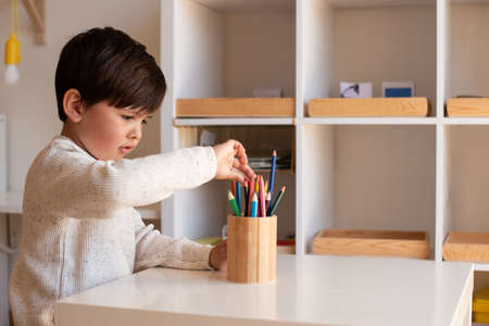 Little preschooler kid drawing with coloured pencils. Homeschooling. Learning community. Montessori school.の写真素材