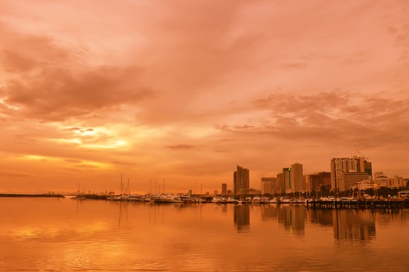 Calm water, boats buildings reflection on warm afternoon.の写真素材