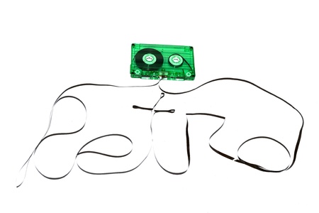 cassette tape isolated on white background with its magnetic tape pulled out of the case and spread in front of it to form the word retro.  の写真素材