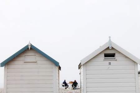 A picnic on the beach next to beach huts の素材