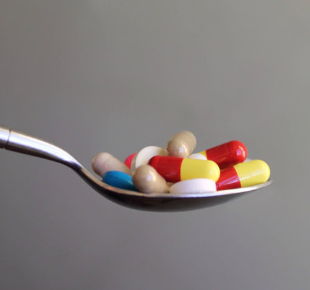 A pile of colorful pills on a spoonの素材