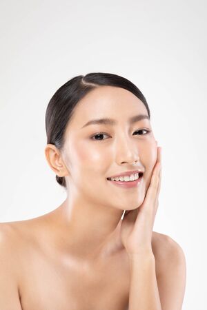 Beautiful Asian young woman touching soft cheek smile with clean and fresh skin Happiness and cheerful with positive emotional,isolated on white background,Beauty and Cosmetics Conceptの写真素材