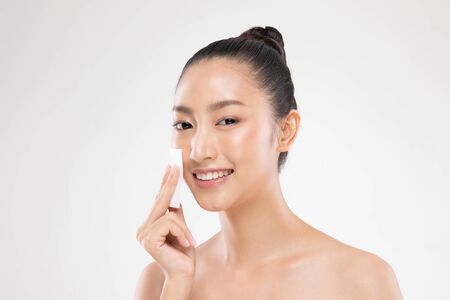 Attractive Charming Asian young woman smile and using tissue with toner for cleaning make up feeling so fresh and clean with healthy skin,isolated on white background,Beauty Cosmetics Conceptの写真素材