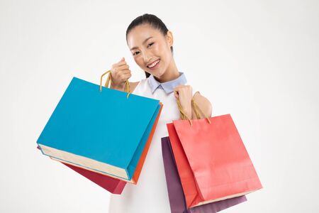 Shopping Asian woman smile and Holding Shopping bags, Cheerful and happiness emotional, Enjoy Shopping in black friday sale, Isolated on gray background, Shopping Conceptの写真素材
