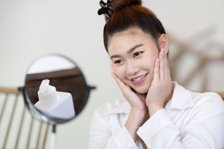Portrait of a Beauty young woman brunette cosmetics looking in the mirror with fresh healthy facial skin,feeling so fresh and happiness,Beauty and Cosmetics Conceptの写真素材