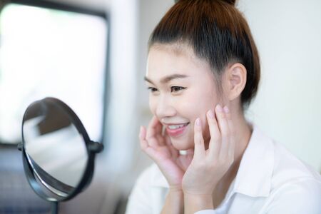 Portrait of a Beauty young woman brunette cosmetics looking in the mirror with fresh healthy facial skin,feeling so fresh and happiness,Beauty and Cosmetics Conceptの写真素材