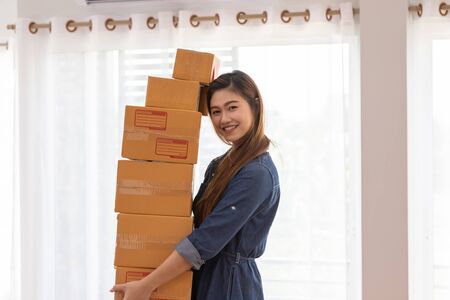 SME entrepreneur Young Asian women lifting packaging order for Online shopping at home,Cheerful and Happy with box for packaging in home,Own Business Start up for Business Online and Online shoppingの写真素材