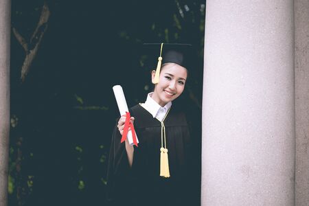 Attractive Beautiful Asian Graduated woman in cap and gown smile with certificated feeling so proud...