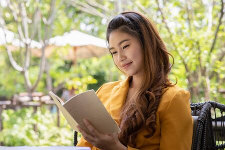 Beautiful Attractive Asian woman reading book for learn and education smile and positive thinking feeling so happiness and comfortable,Education Conceptの写真素材