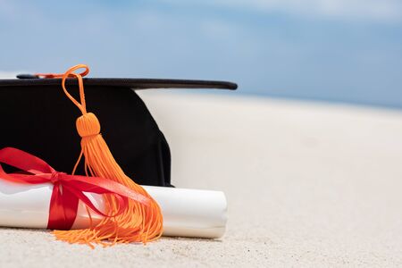 Close up Graduation cap and certificated on the beach with beautiful sea in summer,Education in summer Conceptの写真素材