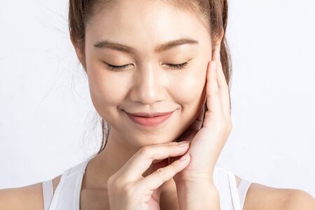Beautiful Attractive Charming Asian young woman smile with white teeth and touching soft cheek feeling so happiness and cheerful with healthy skin,isolated on white background,Beauty Conceptの写真素材