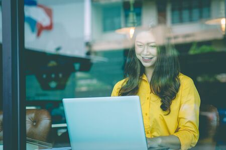 Beautiful Attractive Asian woman working with computer laptop and thinking to get ideas and...