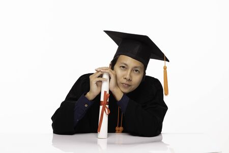 Asian Graduate man in cap and gown smile with certificate or diploma so proud and happiness in...