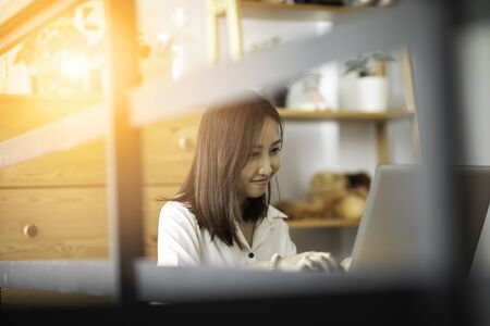 Lifestyle of Beautiful Attractive Asian woman smile working or shopping online with computer laptop in bedroom feeling so happiness and cheerful,Relax in holiday with laptop and using social networkの写真素材