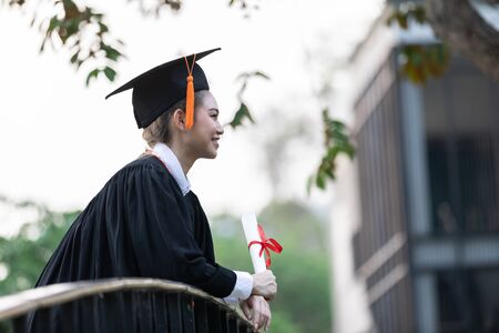 Attractive Asian Women Student Graduate in cap and gown celebrating with certificate in hand and so proud happiness in Commencement day,Congratulation of student in graduation day,Education Successの写真素材