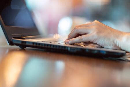Close up hand of business woman working with laptop in coffee shop cafe,Warm tone,Selective focusの写真素材