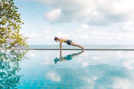 Vacation of Beautiful Attractive Asian young woman practice yoga Plank or Phalakasana Pose on the...