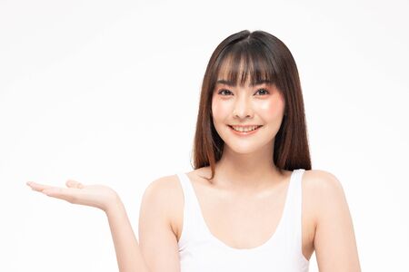 Beautiful Attractive Charming Asian young woman smile with white teeth open hand palm for display cosmetics product cheerful with healthy skin,isolated on white background,Beauty Cosmetics Conceptの写真素材