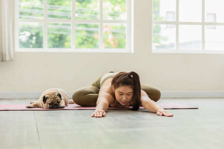 Athletic Asian woman practice yoga Child's pose online course at home to meditation calm comfortable and relax,Health care and Exercise at home Concept,Self-isolation due COVID-19 pandemicの写真素材