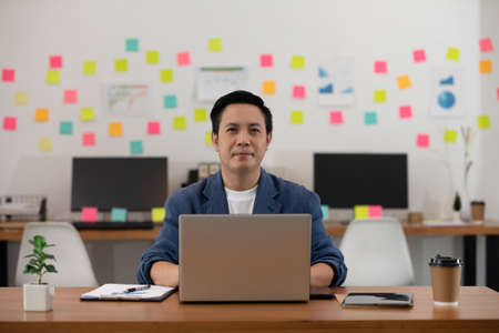 Asian senior business man in casual working with laptop in modern office or co-working space,Business Startup Conceptの写真素材