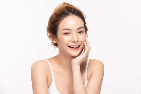 Beautiful Asian young woman touching soft cheek smile with clean fresh skin Happiness and cheerful with positive emotional,isolated on white background,Beauty Cosmetics and Facial treatment Conceptの写真素材