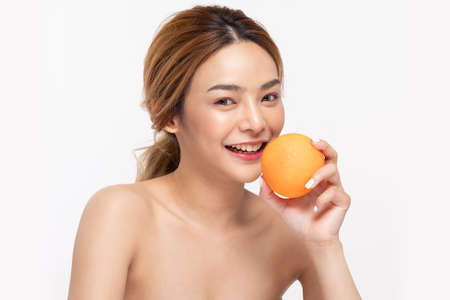 Beautiful Young Asian Woman Holding orange vitamin c smile feeling so happy and cheerful with healthy Clean and Fresh skin,isolated on white background,Beauty Cosmetics spa and treatment Conceptの写真素材