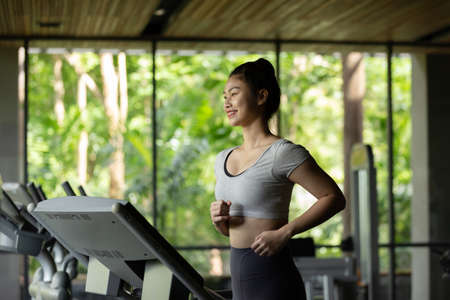 Athlete attractive young sports asian woman workout running on treadmill and cadio in gymAthlete attractive young sports asian woman workout running on treadmill and cadio in gymの写真素材