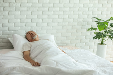 Asian Elderly man close eyes smile sleep and sweet dream on bed in bedroom in the morning feeling so relax and comfortable,Healthcare and Sleep Conceptの写真素材