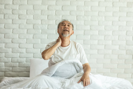Elderly asian man wake up with neck and shoulder pain on bed,Healthcare Conceptの写真素材