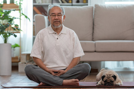Asian elderly senoir man doing yoga with dog pug breed in living room at home,Happy Retired at home conceptの写真素材