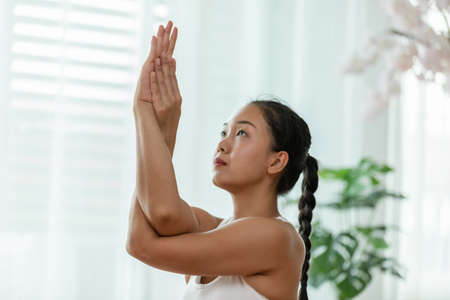 calm of Attractive Asian woman practice yoga Eagle arms pose pose to meditation in bedroom after wake up in the morning Feeling so comfortable and relax,Healthcare Conceptの写真素材