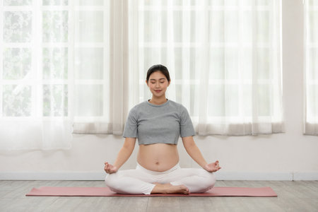 Happy Calm Pregnant Woman deep breath with fresh air do yoga lotus pose comfortable at home,Pregnancy of young woman relax with yoga to meditation for healthy life,Yoga Motherhood and Pregnant Conceptの写真素材