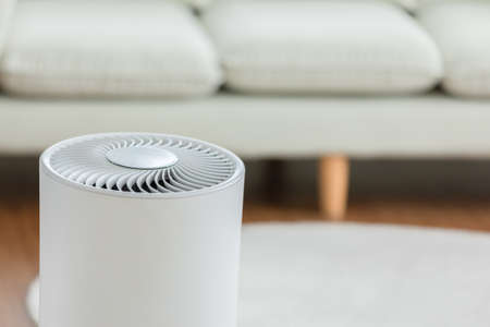 Close up Air purifier in cozy white living room for filter and cleaning removing dust PM2.5 HEPA and...