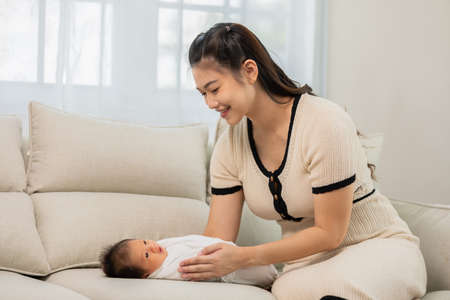 Beautiful Attractive Asian mom  take care baby and lovely at home.Happy mother and infant baby...
