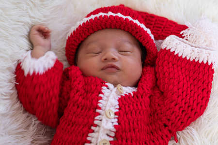 Cute Newborn baby wearing santa costume lying and sleep waiting for celebrate merry christmas and...
