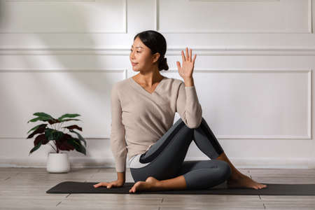 Calm of Asian woman in sportwear stretching muslce to warm up breathing and meditation with yoga at...