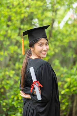 Attractive Asian Women Student Graduate in cap and gown celebrating with certificate in hand and so proud happiness in Commencement day,Congratulation of student in graduation day,Education Successの写真素材