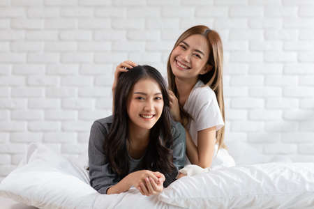 Beautiful two female LGBT lesbian embracing and looking together with love and romance on bed.Positive mood and moment of LGBTQ lesbian lying on white bed relax and comfort.LGBTQ Lifestyle Conceptの写真素材