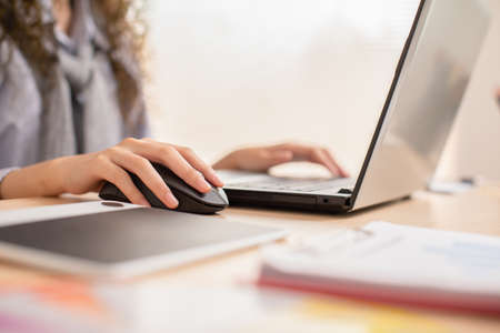 Close up hand of business asian young woman with curly hairstyle holding digital computer mouse and...