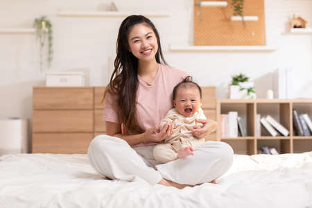 Adorable newborn baby smile and relax in mother arm safety and comfortable.Healthy Asian newborn...