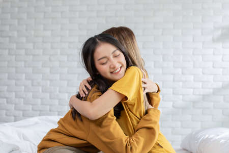Beautiful two female LGBT lesbian embracing and looking together with love and romance on bed.Positive mood and moment of LGBTQ lesbian lying on white bed relax and comfort.LGBTQ Lifestyle Conceptの写真素材