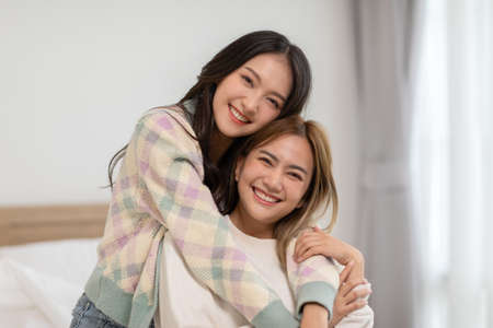Beautiful two female LGBT lesbian embracing and looking together with love and romance on bed.Positive mood and moment of LGBTQ lesbian lying on white bed relax and comfort.LGBTQ Lifestyle Conceptの写真素材