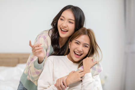 Beautiful two female LGBT lesbian embracing and looking together with love and romance on bed.Positive mood and moment of LGBTQ lesbian lying on white bed relax and comfort.LGBTQ Lifestyle Conceptの写真素材
