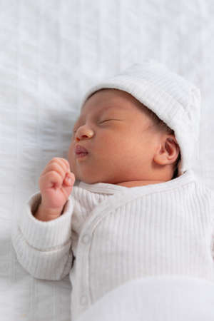 Top view happy newborn baby lying sleeps on a white blanket comfortable and safety at warmth place....