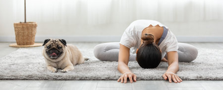 Asian woman doing yoga with her pug breed dog in a peaceful setting, cultivating a sense of harmony and wellness in both body and mind. Self Care Concept.の写真素材